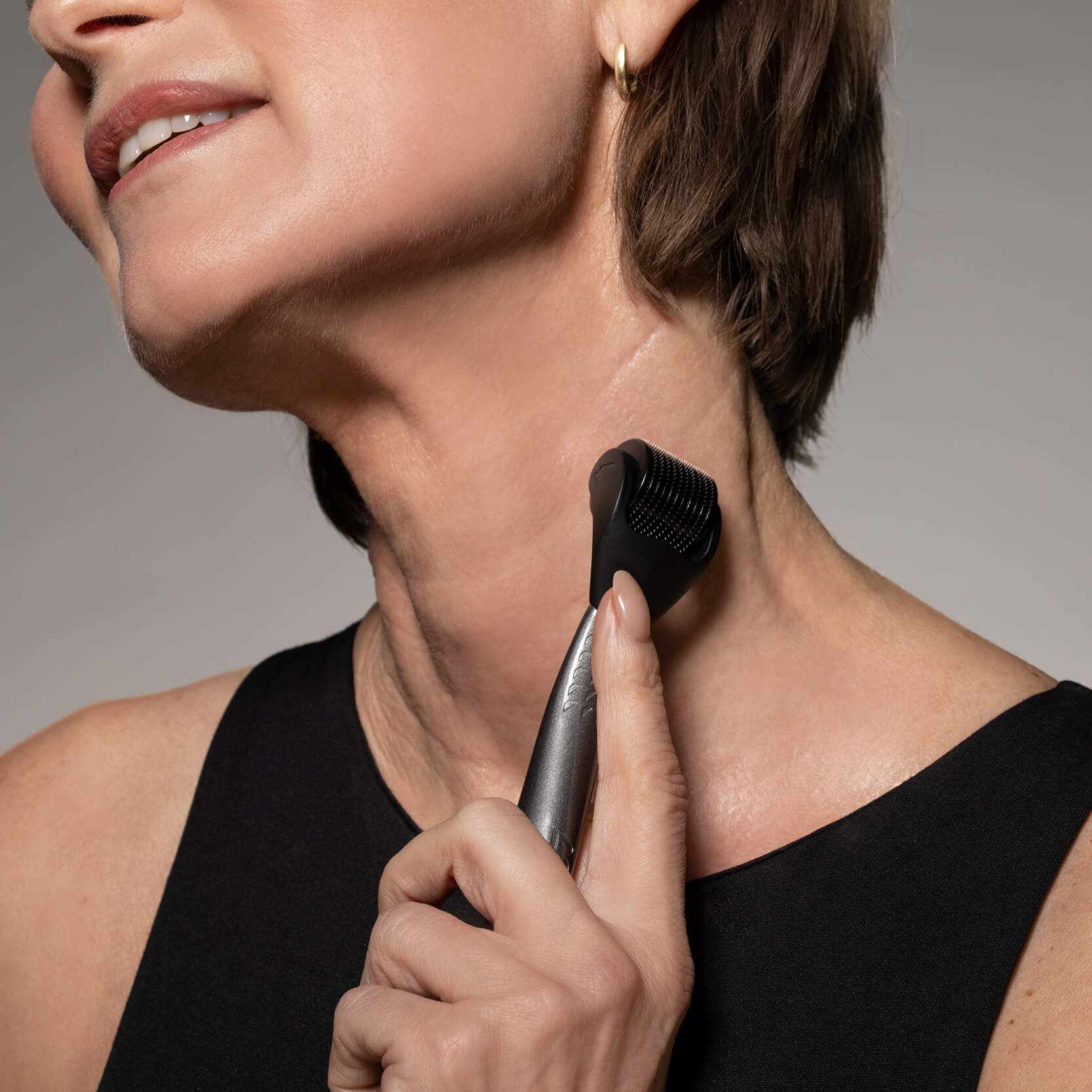vrouw gebruikt LAYZIN Anti-Aging Microneedling SET dermaroller op de hals voor huidverjonging en versteviging