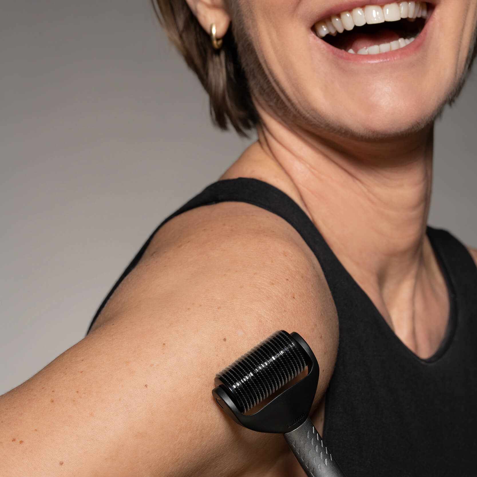 Vrouw gebruikt Litteken en Striae Microneedling 2 rollerkoppen SET op arm voor huidverbetering.